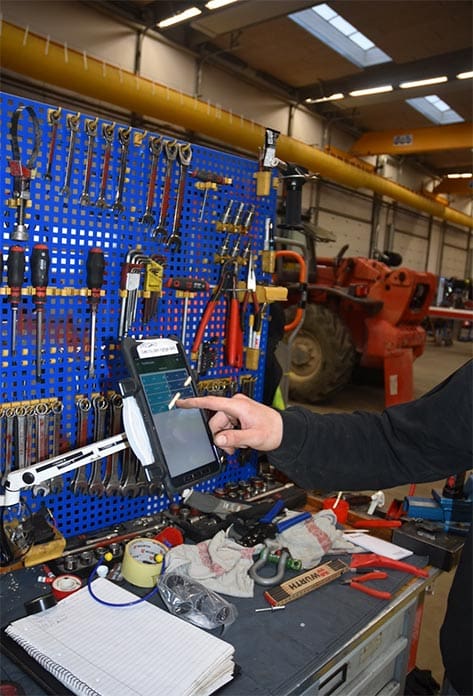 bild på en verkstad där en person trycker på en terminal