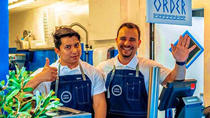 bild på två arbetare från Gyros Heros som vinkar och ler med tummen upp