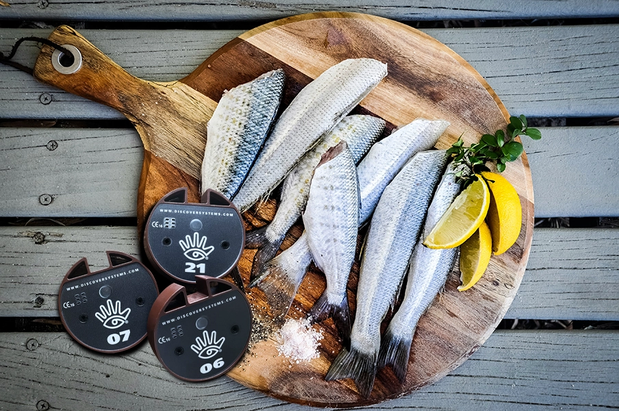 Ett träfat med rökt sill, citron och tre personsökare från Discover Systems