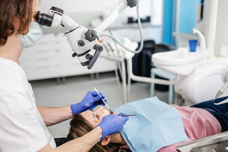 UnitCall, ljust rum där en tandläkare tittar på en patients tänder med ett mikroskop